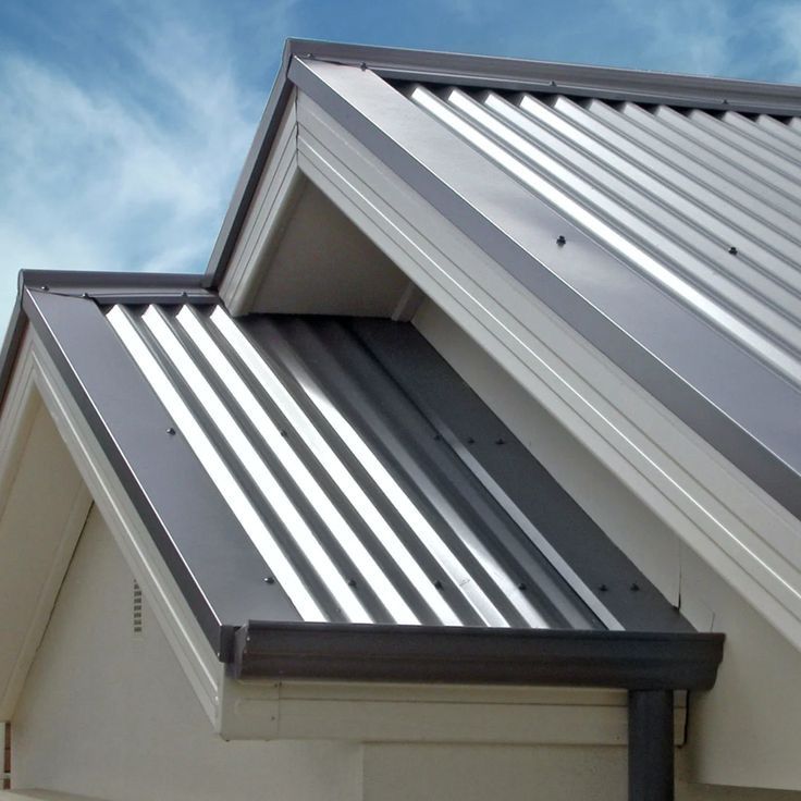Modern corrugated metal roofing with silver panels, metal flashings, box gutters, and fascia, shown under a clear blue sky. — Apex Roofing Group in Banora Point, NSW