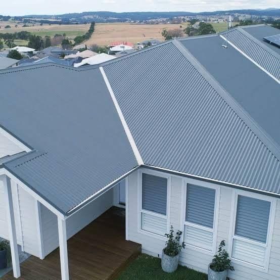 An Aerial View of A House with A Blue Roof — Apex Roofing Group in Mullumbimby, NSW