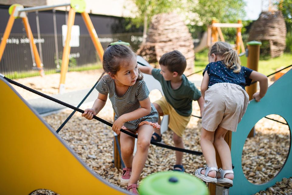 Children climbing on a colorful playground play structure outdoors