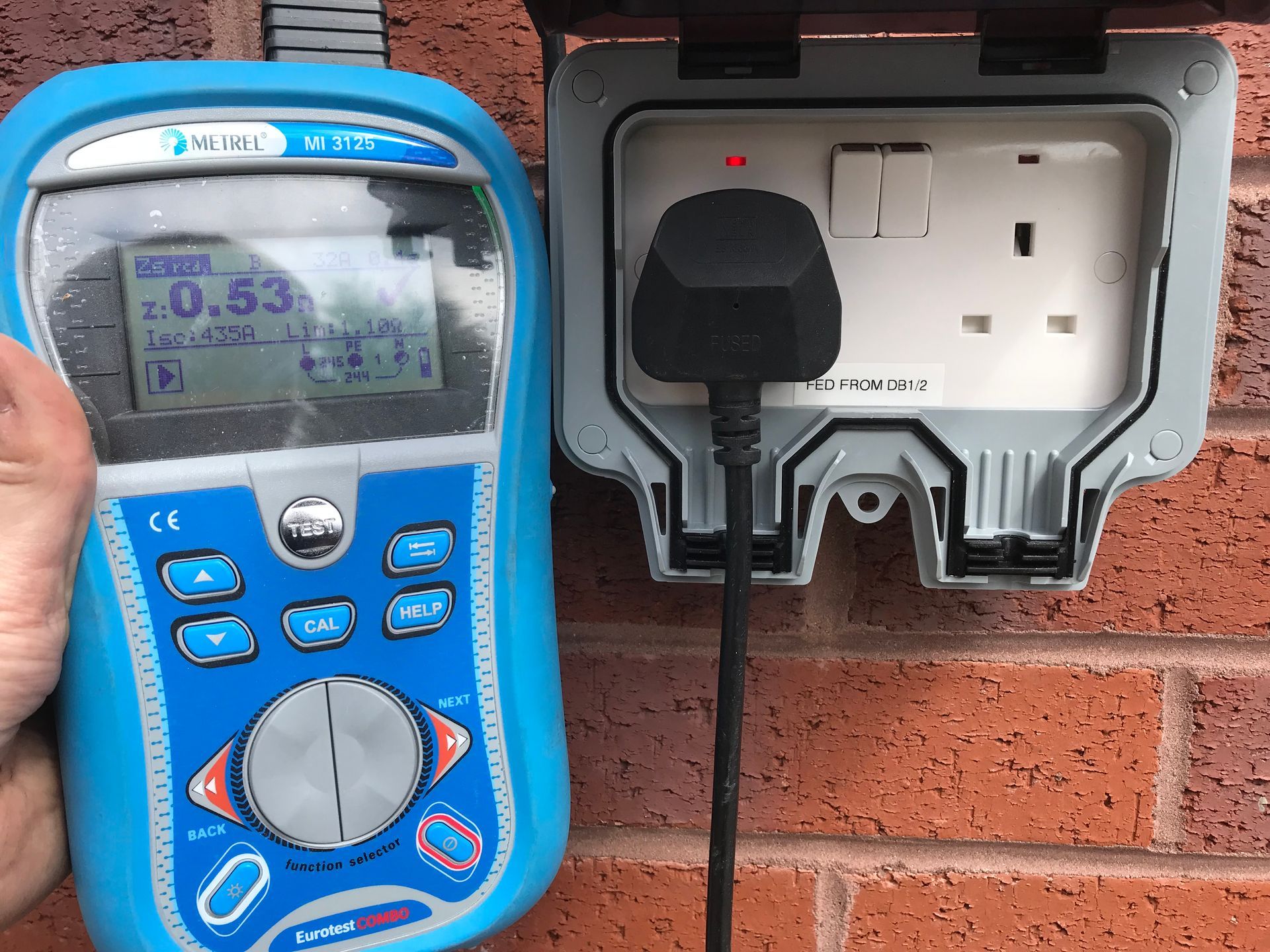 Outdoor electric socket installed on a garden wall by AJOB Electrical Ltd.