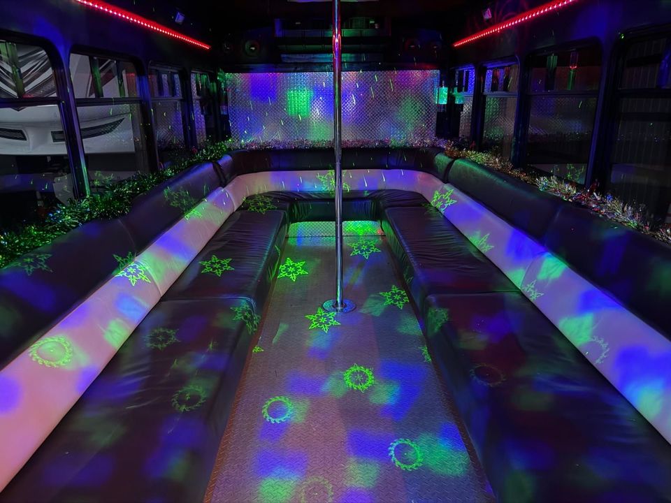 Empty party bus interior with glowing green and purple disco lights on benches and floor