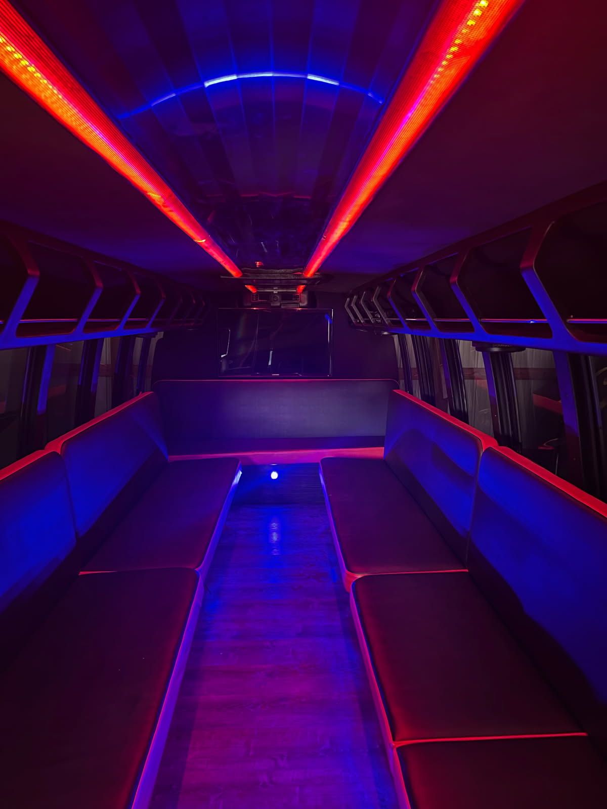 Neon-lit tunnel with red and blue lights reflecting on a metallic walkway