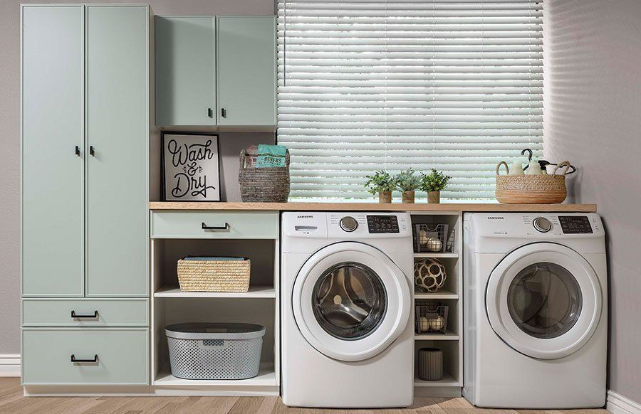 Laundry room with mint cabinets, two front-load washers, shelves, and window blinds