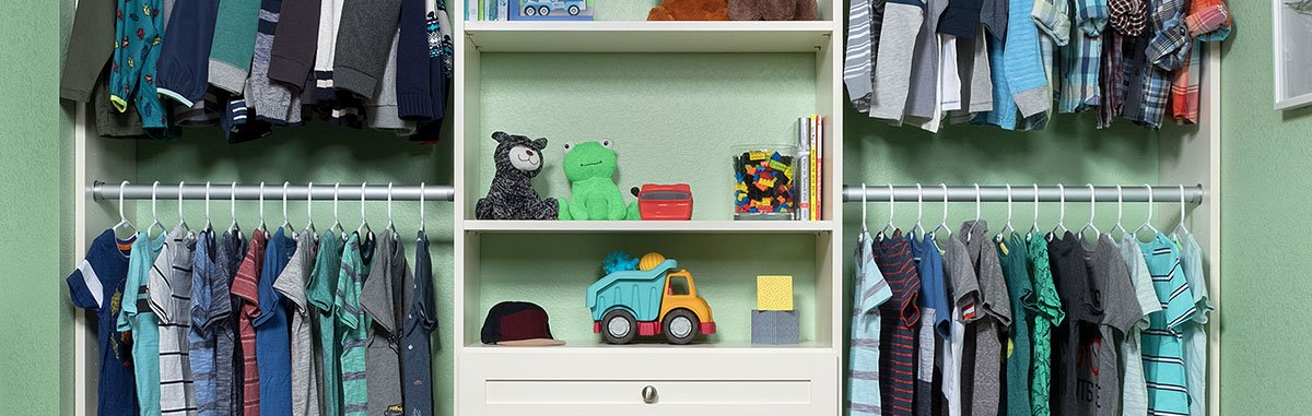 Open closet with hanging clothes and shelves holding folded items and toy cars