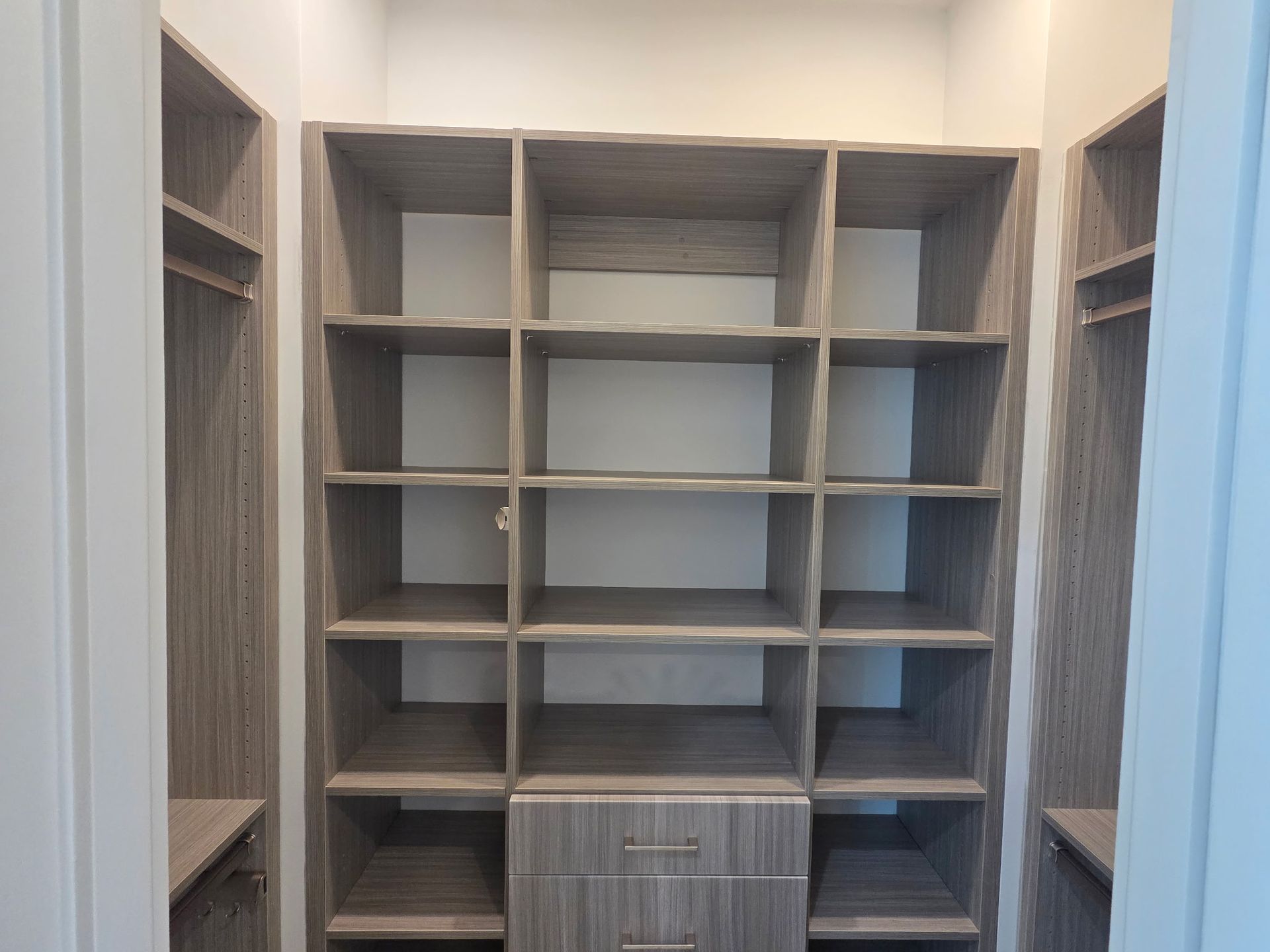Empty gray built-in shelving unit with a small drawer in a bright room