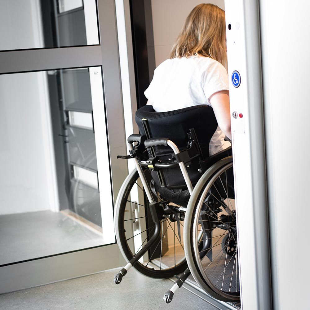 Wheelchair user entering an accessible elevator with mobility friendly design. Wheelchair user entering an accessible elevator with mobility friendly design.