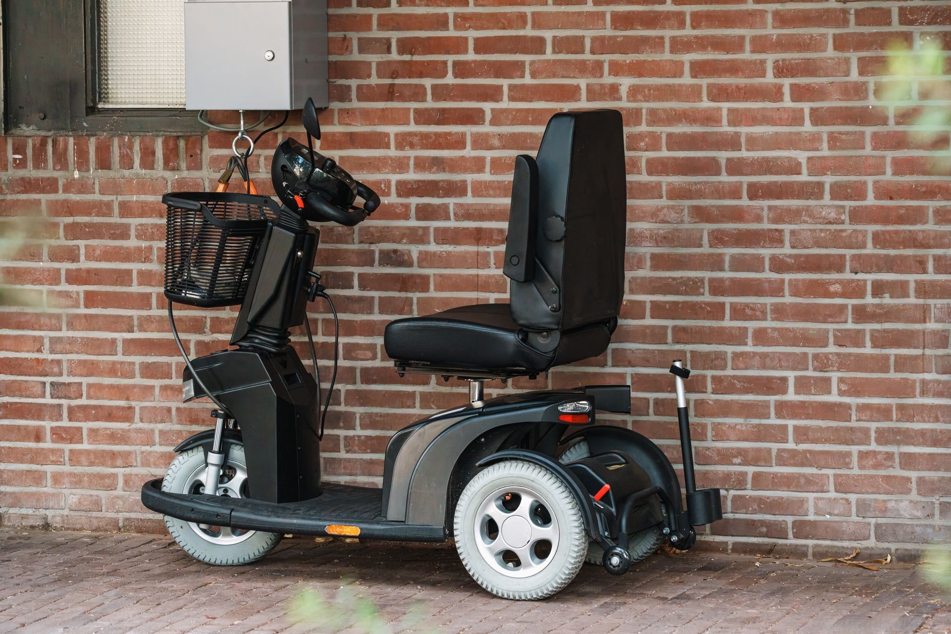 Assistive scooter parked outside building. Assistive scooter parked outside building.