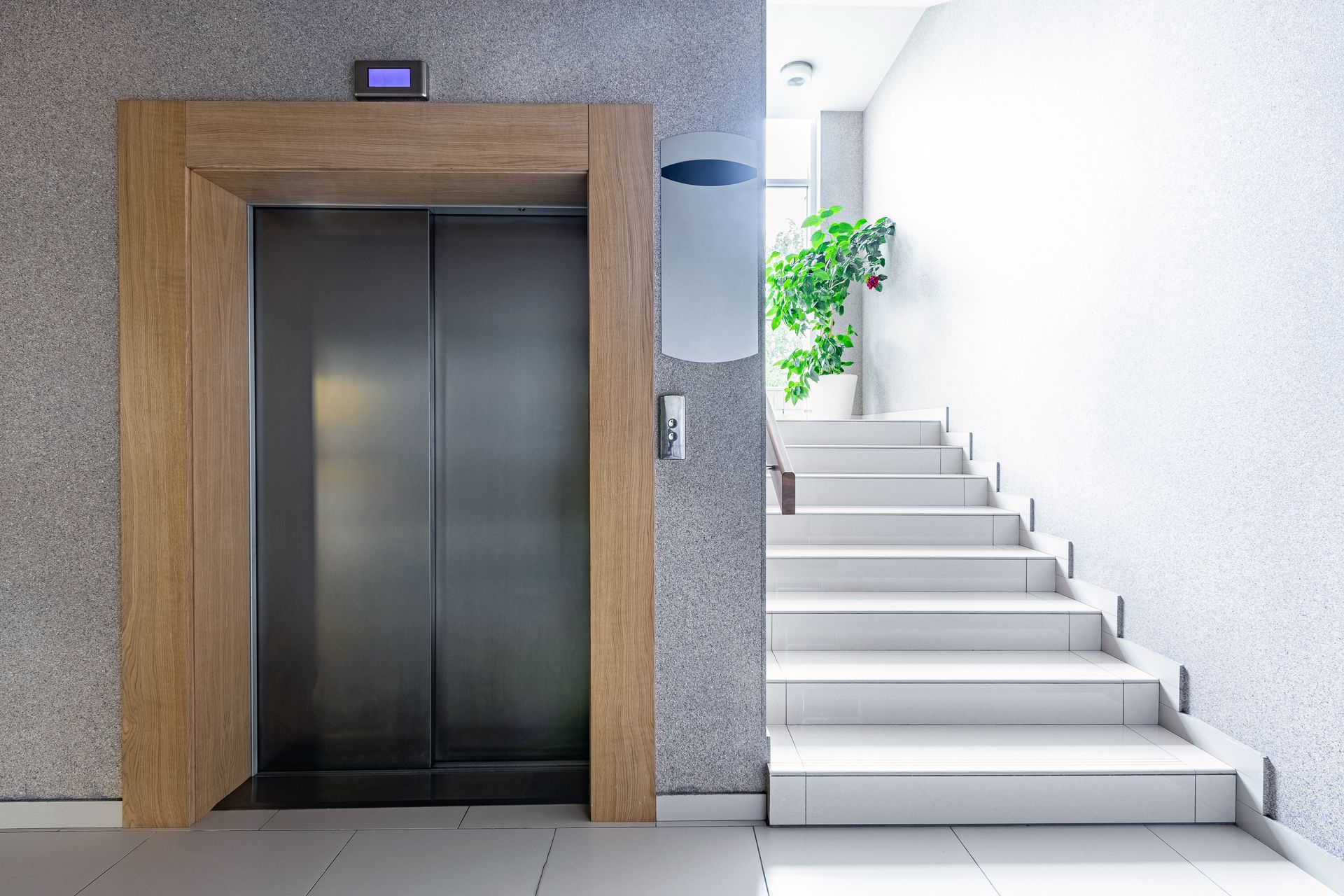 Modern wood-frame elevator beside bright stairs, minimalist with natural light. Modern wood-frame elevator beside bright stairs, minimalist with natural light.