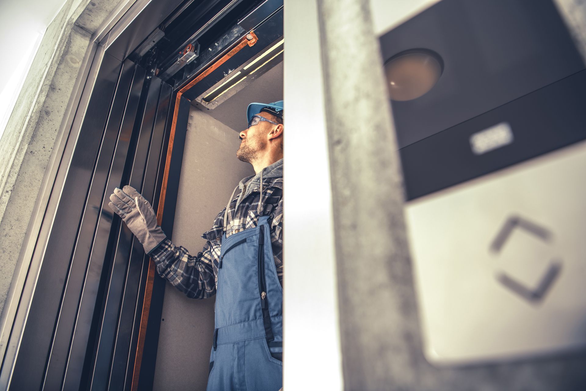 A home elevator installation expert is inspecting lift shaft panels inside a residential building A home elevator installation expert is inspecting lift shaft panels inside a residential building