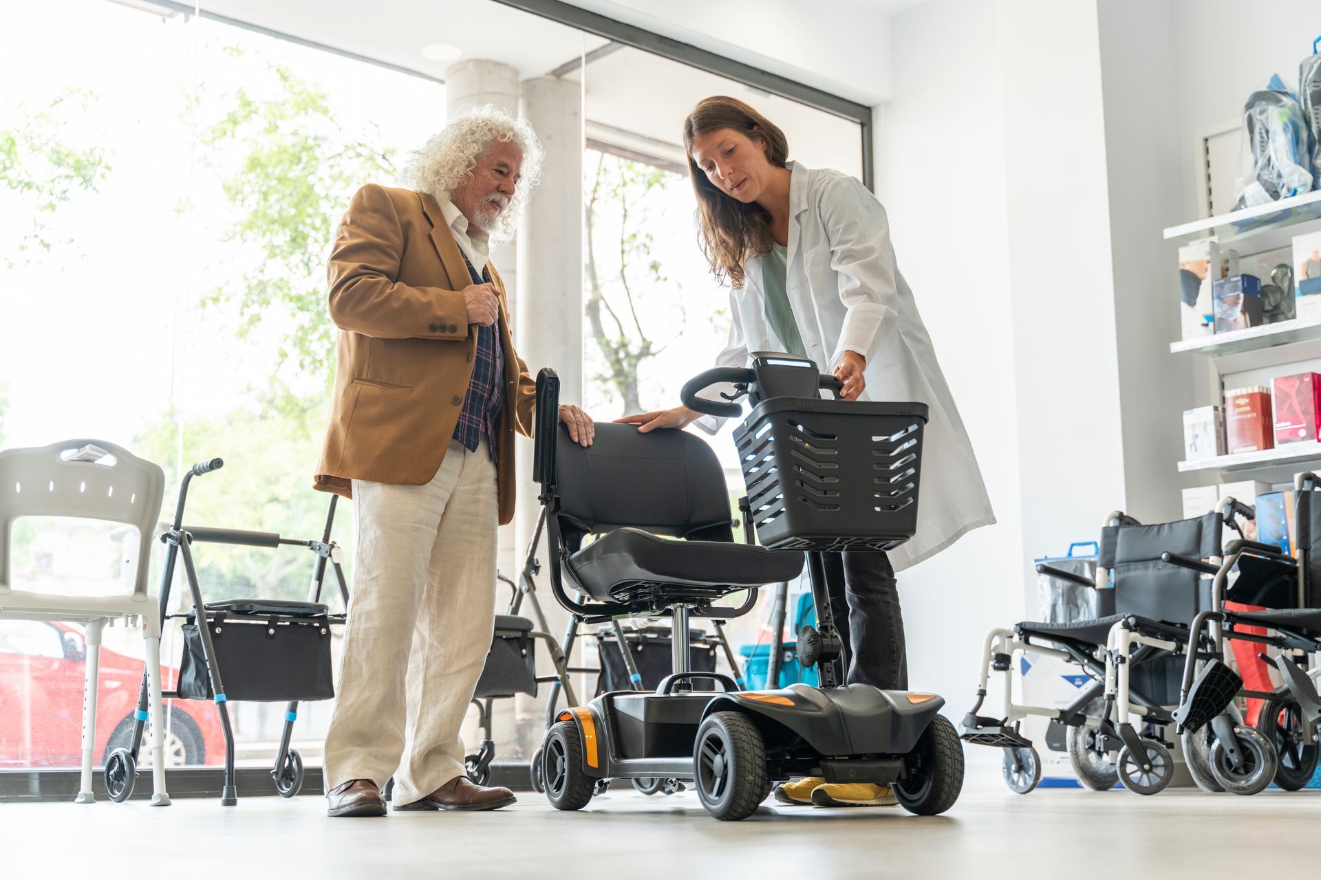 An older man in a scooter shop trying out an electric scooter. An older man in a scooter shop trying out an electric scooter.