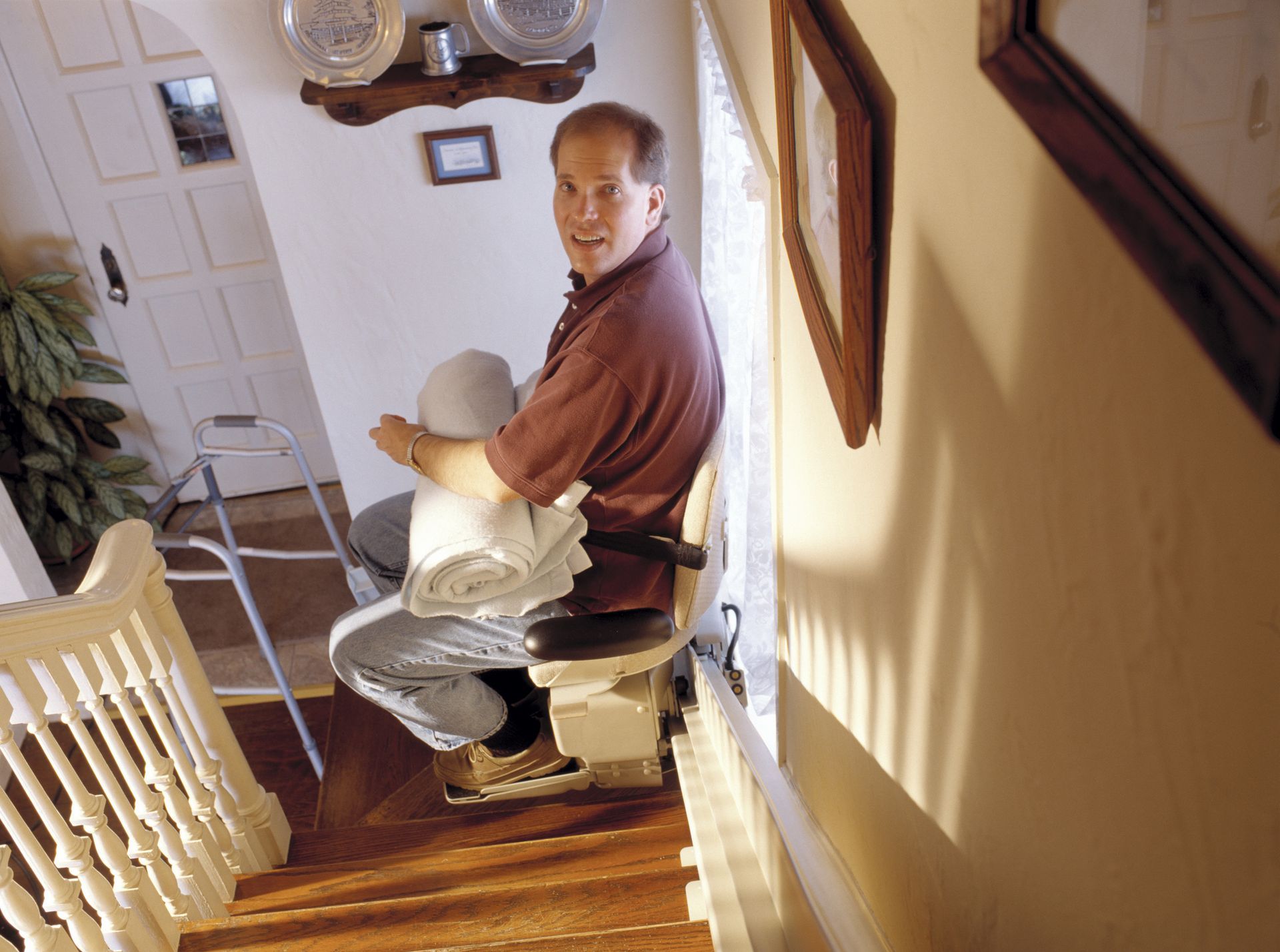 Man in stair lift doing chores.