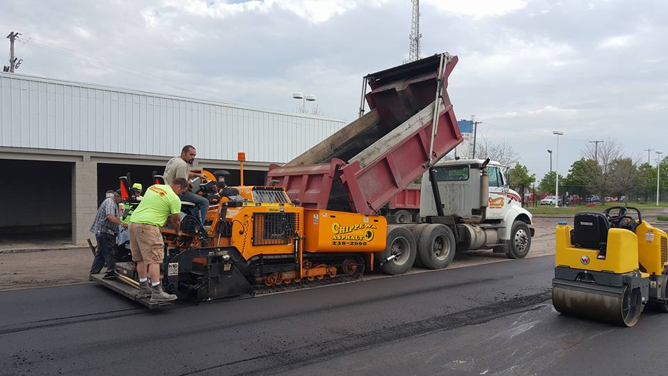 Big Truck Passing Cement On The Machine With Three Man - Clio, MI - Chippewa Asphalt Paving Big Truck Passing Cement On The Machine With Three Man - Clio, MI - Chippewa Asphalt Paving