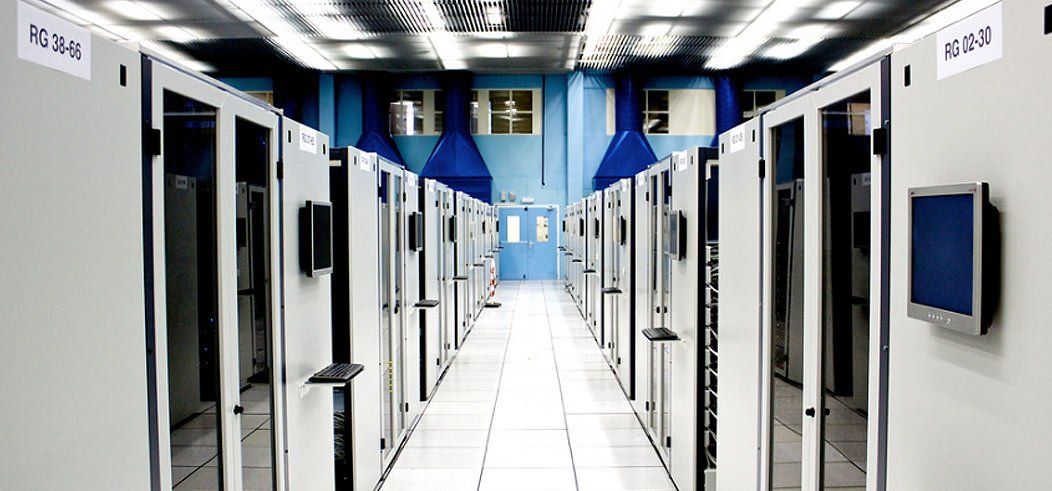 Rows of server racks in a data center with blue accents.