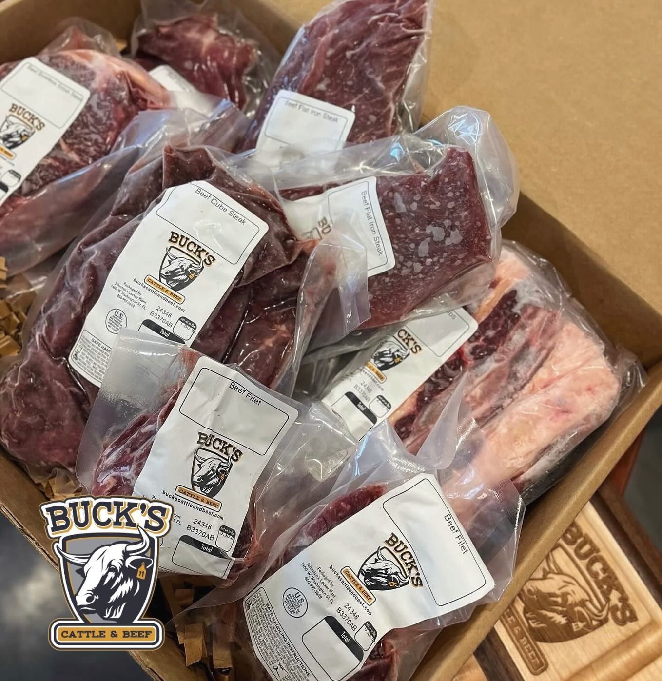 Box of vacuum-sealed raw meat packages with Buck's logo labels.