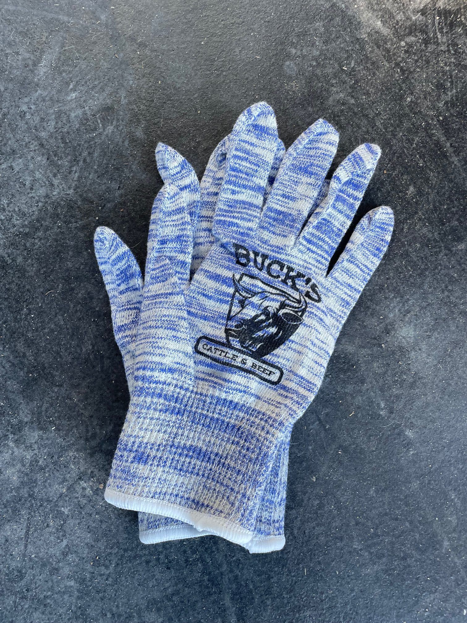 Blue-and-white knit work glove on a dark textured surface