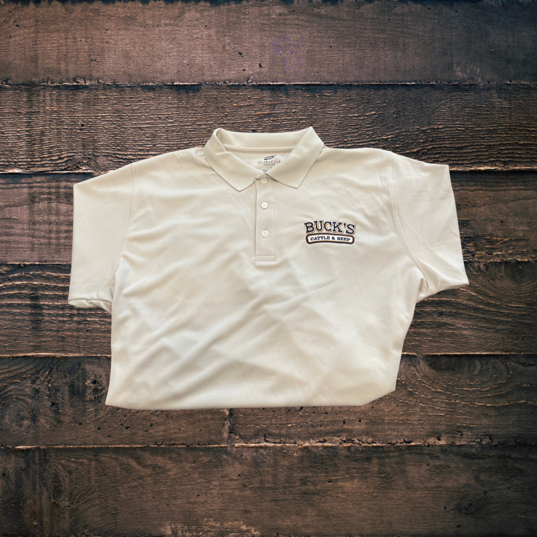 White short-sleeve polo shirt with a small logo, laid flat on a rustic wooden background.
