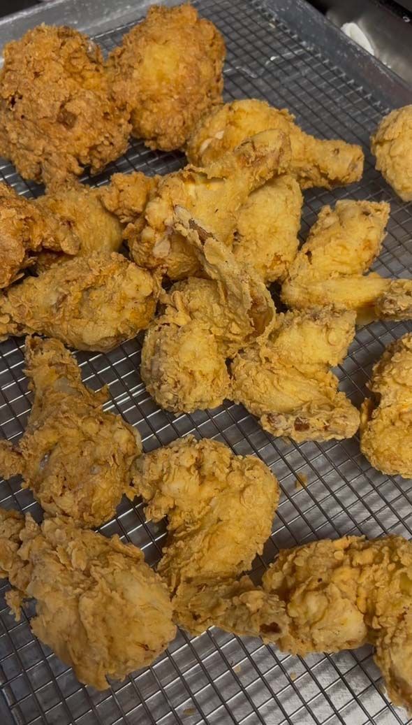 Golden fried chicken pieces arranged on a wire rack.