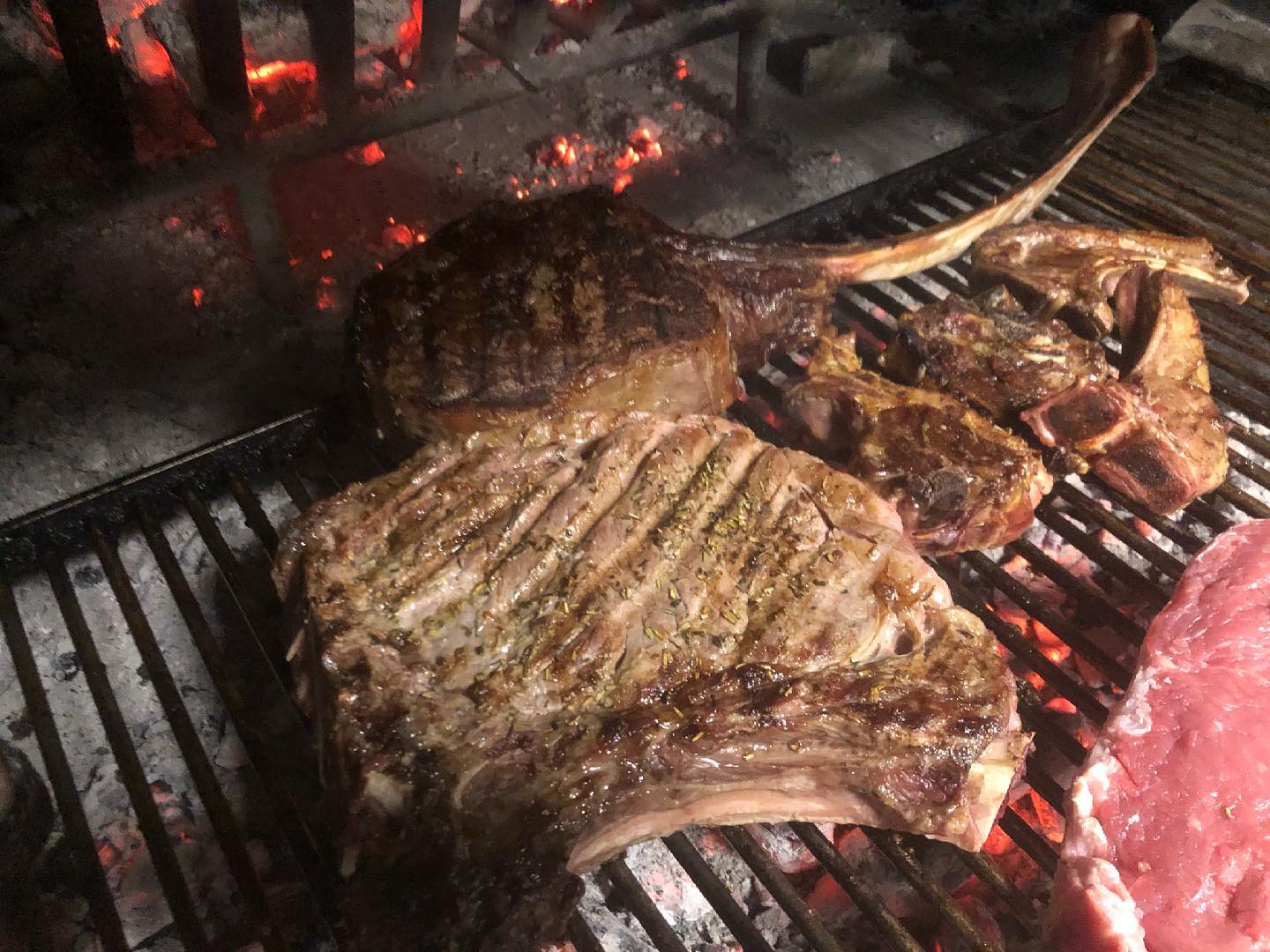 Un grosso pezzo di carne sta cuocendo su una griglia.
