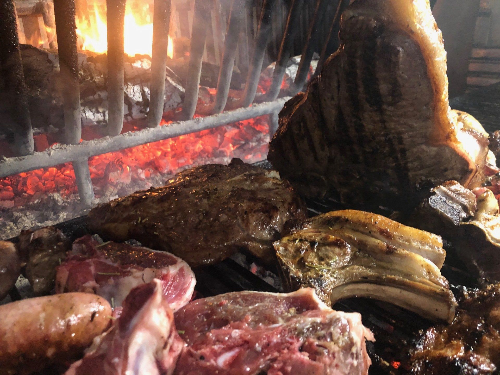 Un grosso pezzo di carne viene cucinato su una griglia.