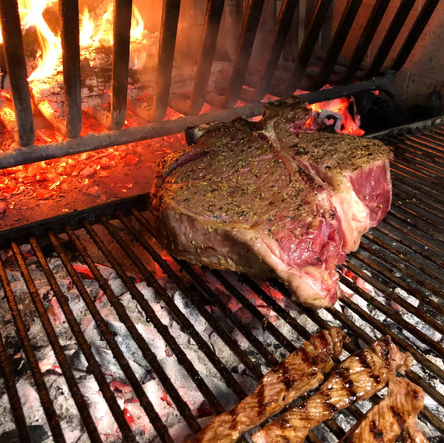 Un grosso pezzo di carne sta cuocendo su una griglia