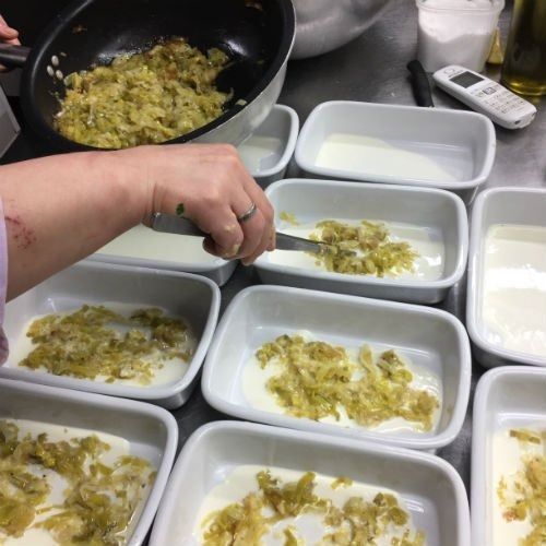 Una persona sta cucinando del cibo in una padella in cucina