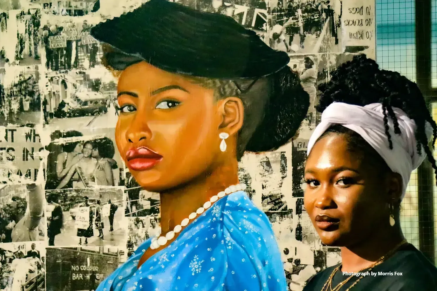 Woman in portrait, light skin, blue dress, black hat next to woman with dark skin, white headwrap.