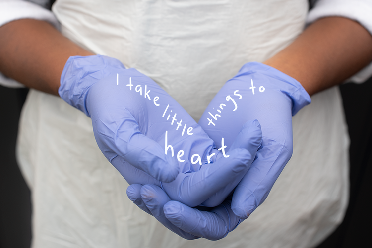 Hands in blue gloves hold the words 