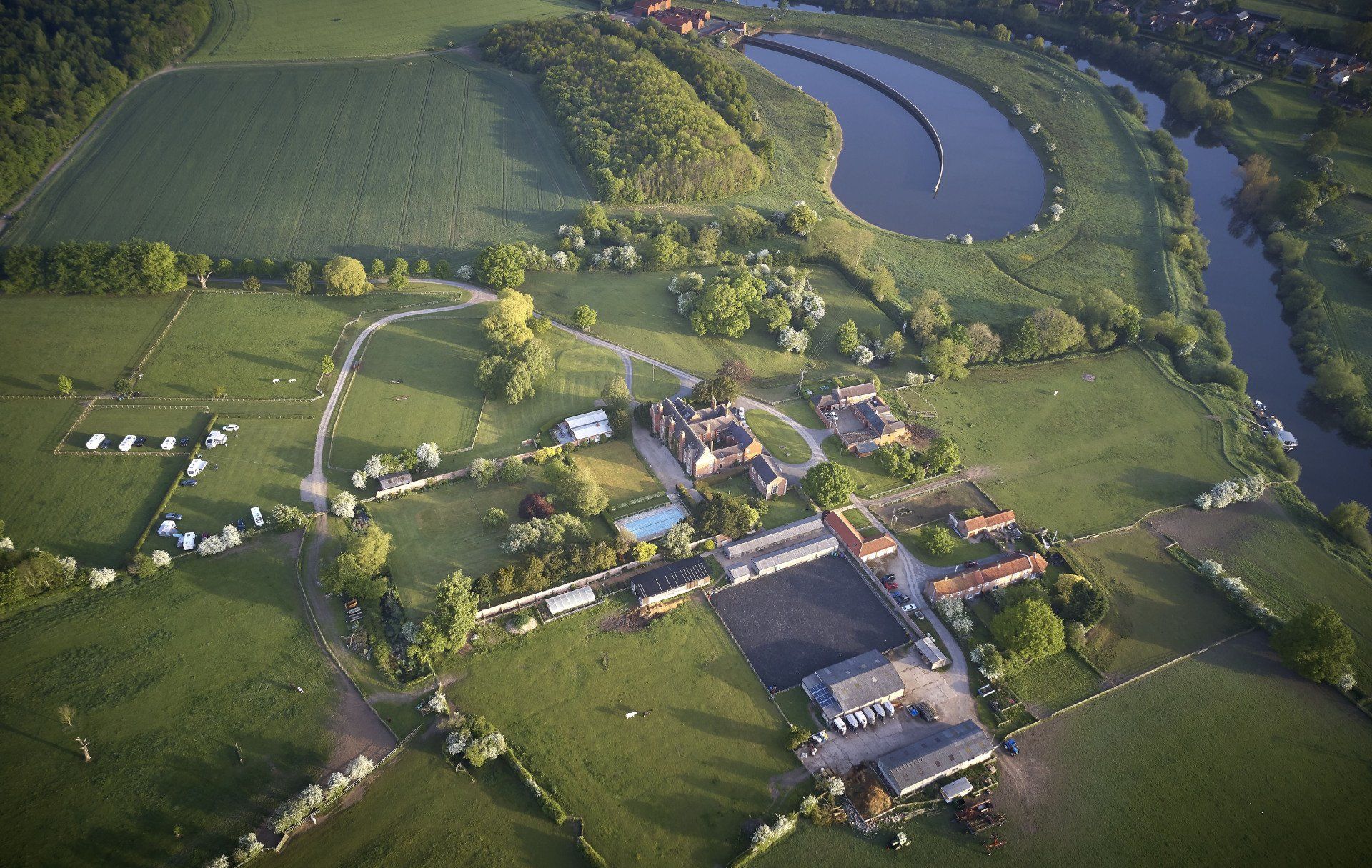 An aerial view of a farm with a river running through it