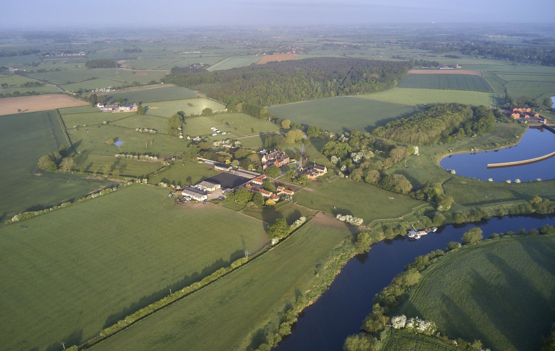 An aerial view of a river surrounded by fields and trees