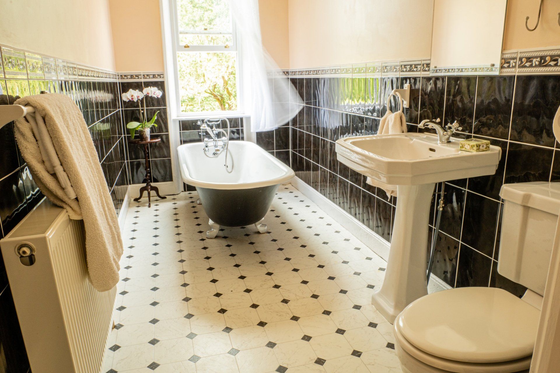 A bathroom with a bathtub , sink , toilet and window.