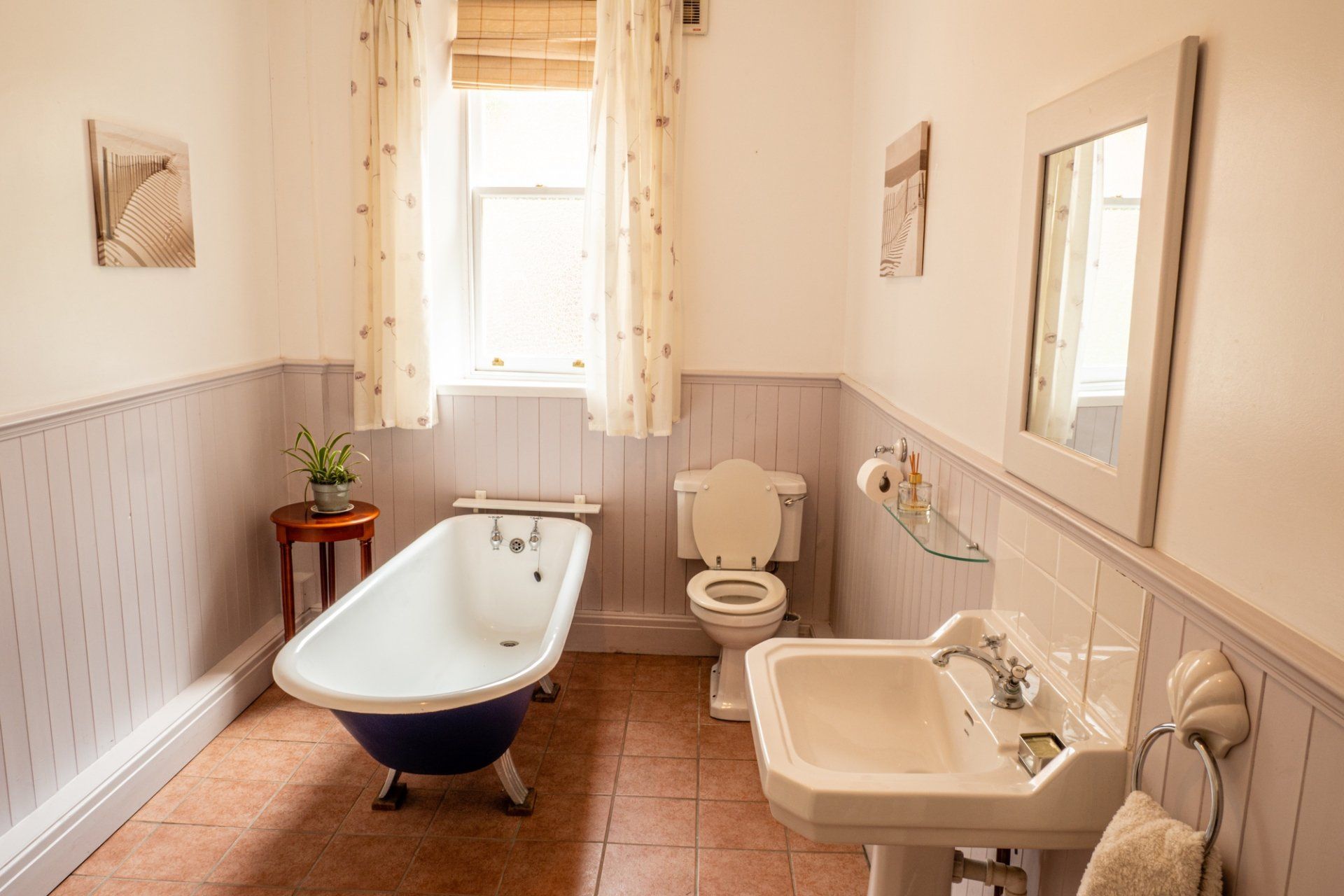 A bathroom with a bathtub , toilet , sink and mirror.