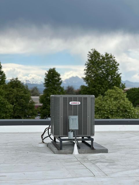 Groulx Mechanical - A large air conditioner is sitting on top of a roof.
