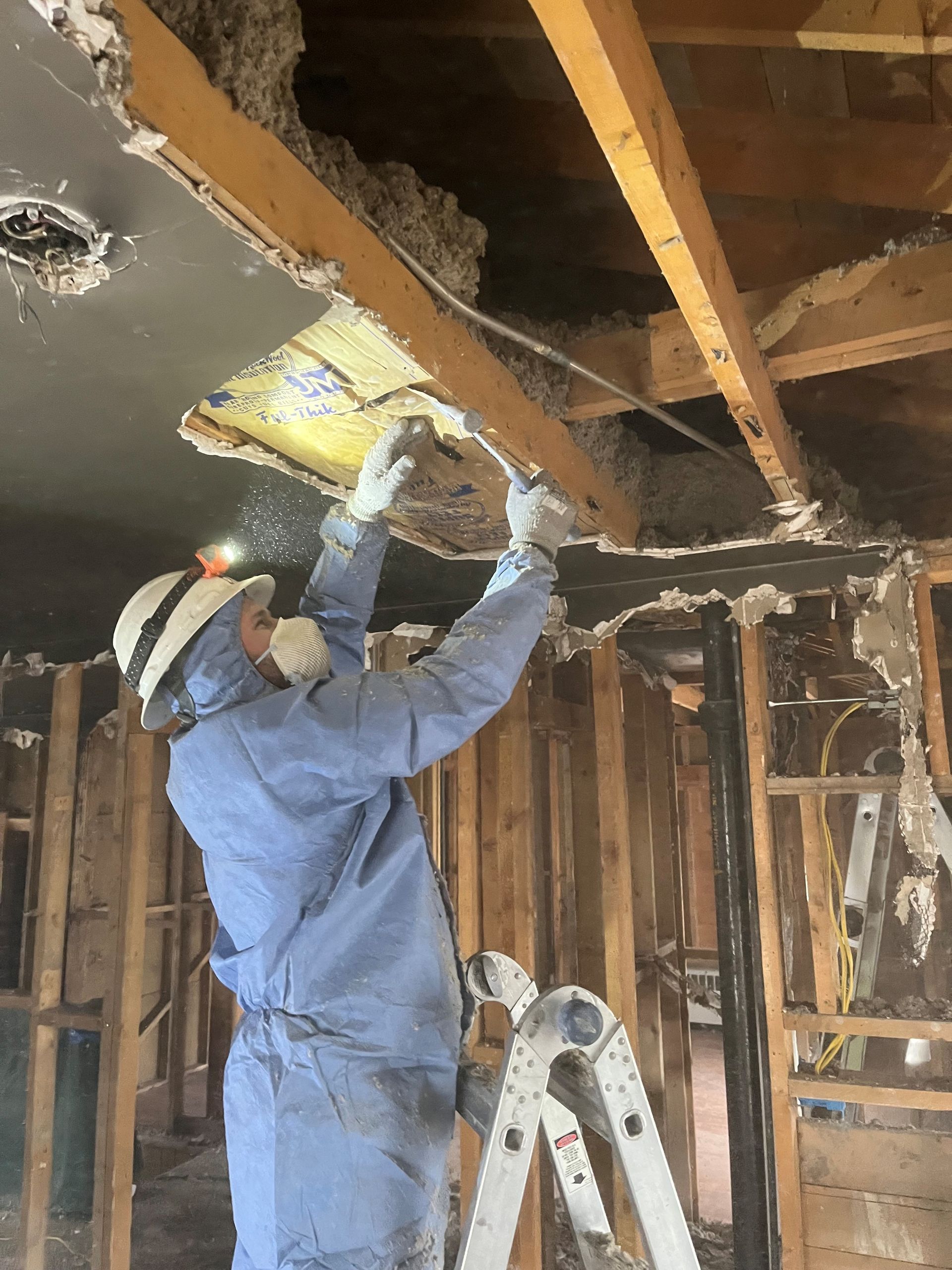 HRS Restoration Services roofing specialist removing damaged insulation in Denver Colorado