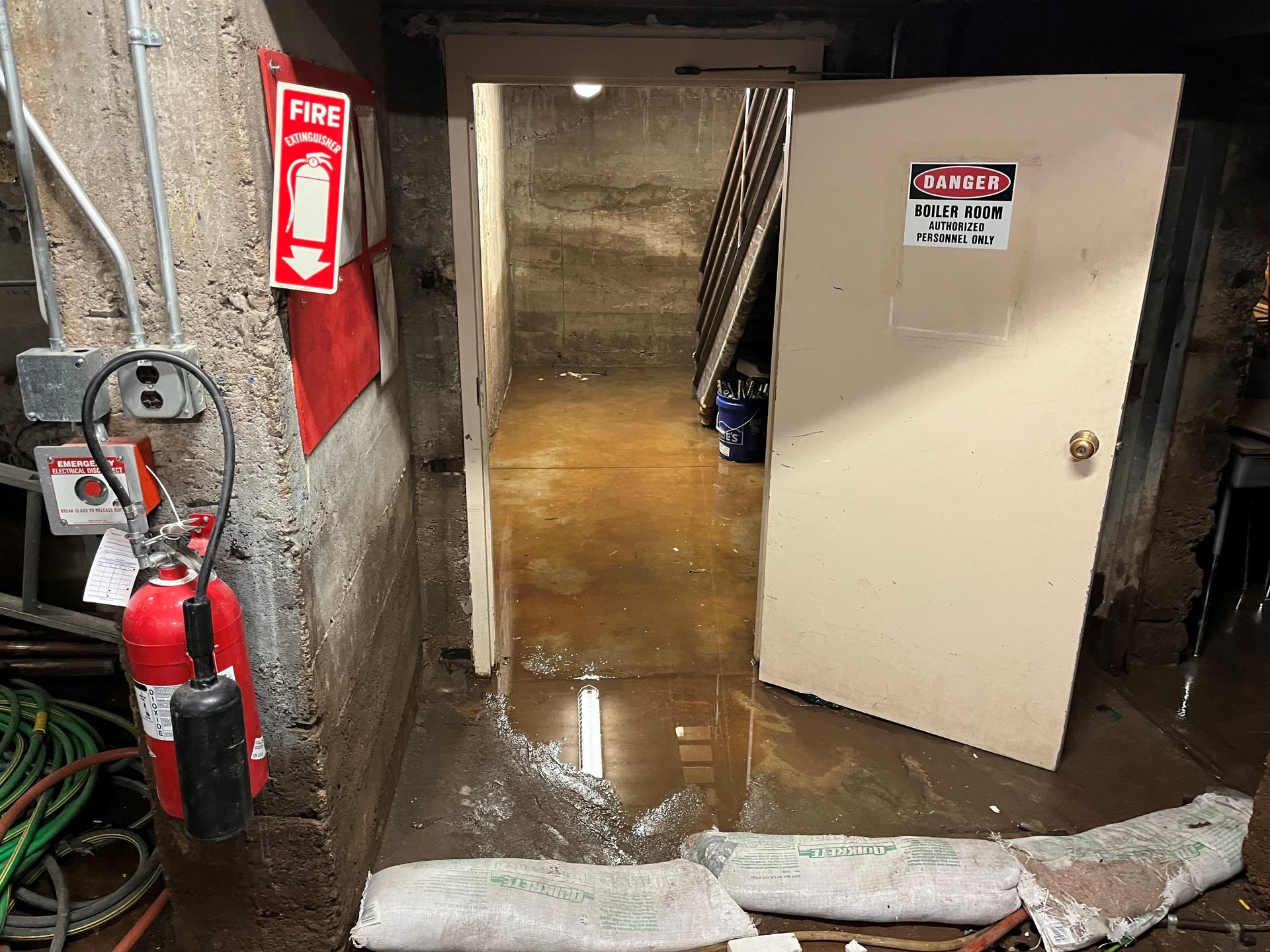 Flooded boiler room in Denver requiring emergency water damage restoration. HRS uses sandbags and pumps water before cleanup.