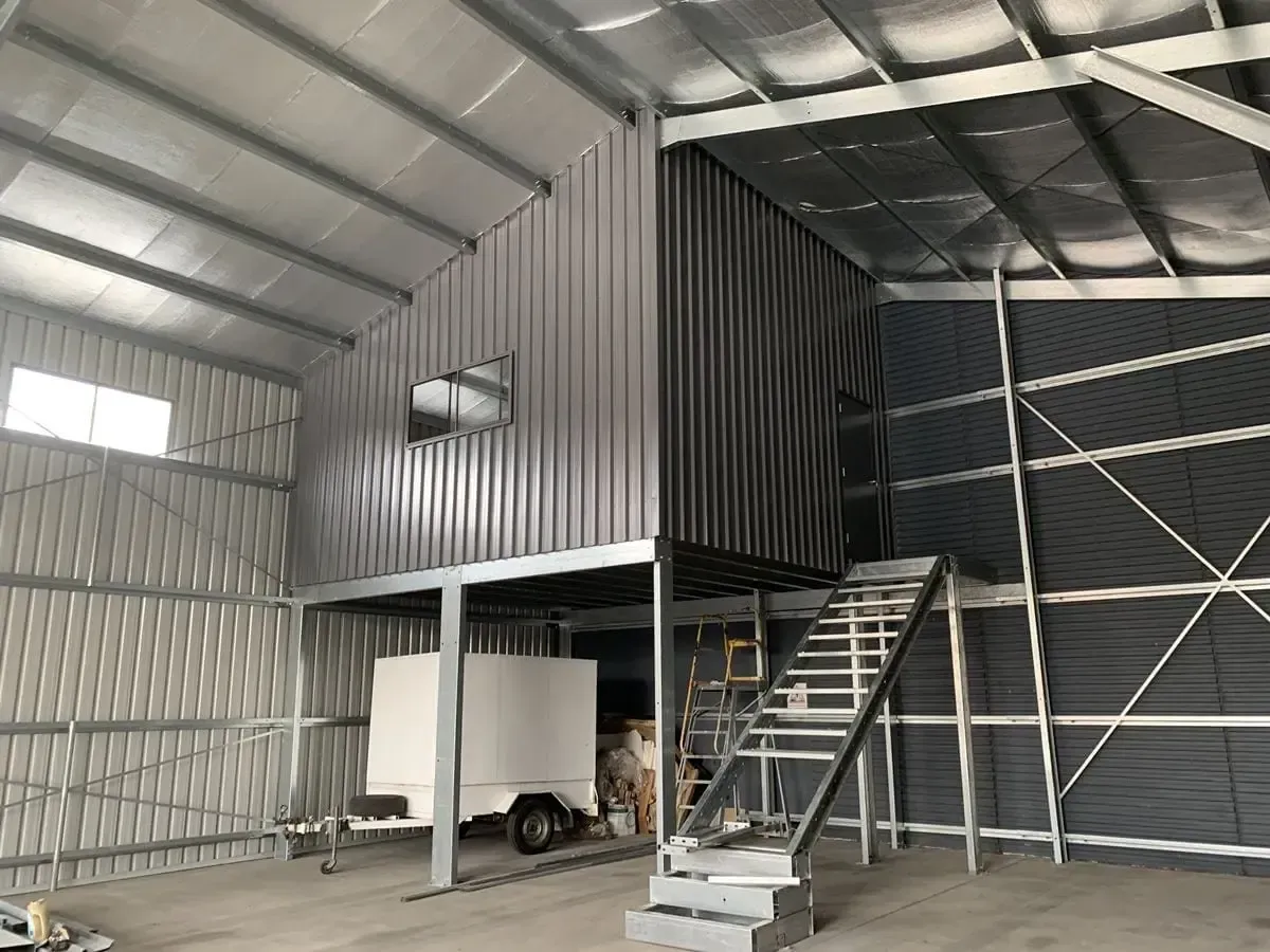 A Large Warehouse With Stairs Leading Up to a Second Floor — ShedPro Constructions in Darawank, NSW