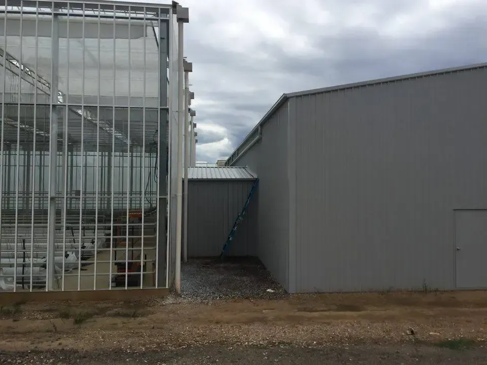 A Large Building With a Staircase Leading to It — ShedPro Constructions in Darawank, NSW