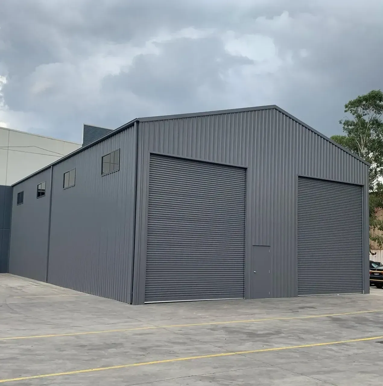 A Row of Storage Units with Yellow Doors and A Snowboard in One of Them — ShedPro Constructions in Darawank, NSW