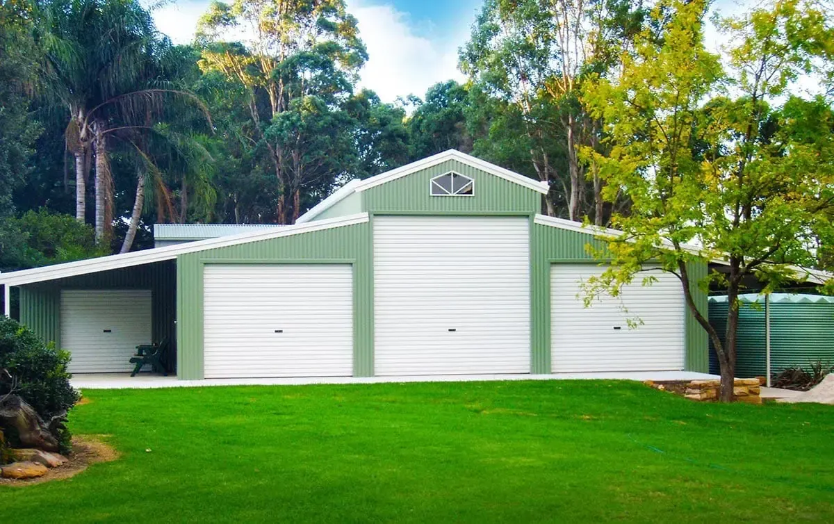 A Green and White Garage Is Sitting on Top of A Lush Green Lawn — ShedPro Constructions in Darawank, NSW