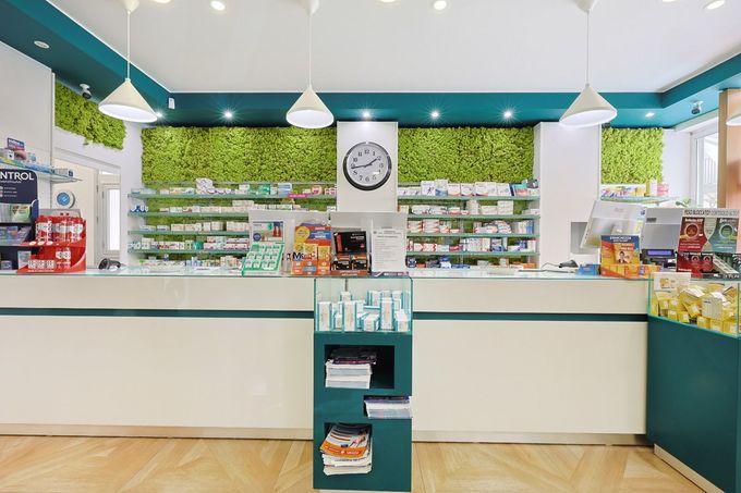 Farmacista che consegna scatole di medicinali a un cliente al banco della farmacia
