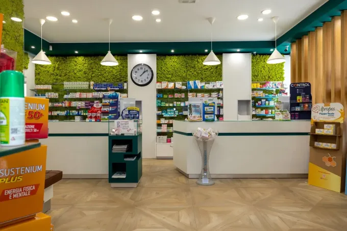 Selezionando a mano una bottiglia bianca di medicinale da uno scaffale di prodotti da farmacia in una farmacia.