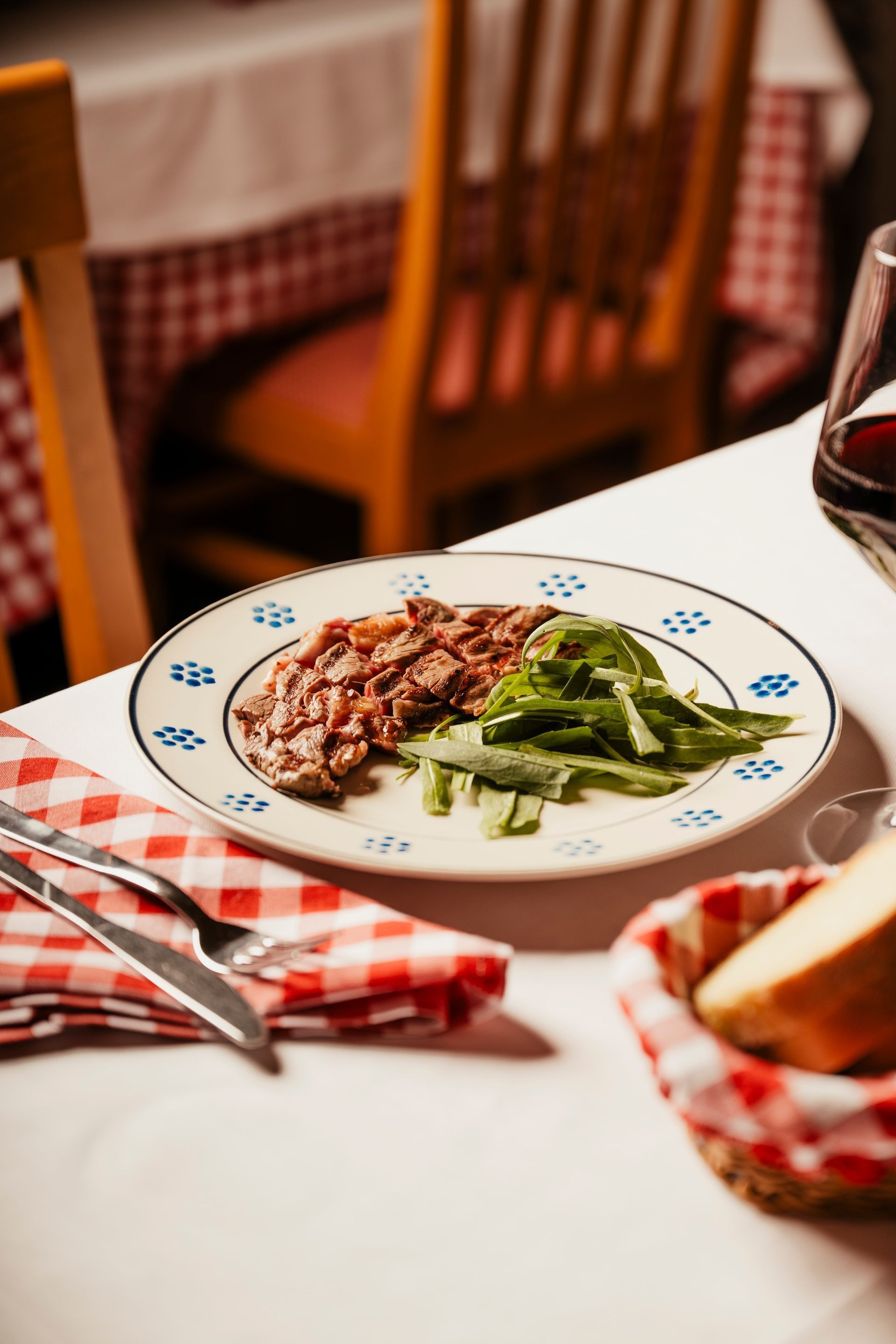 Un piatto di bistecca e asparagi su una tovaglia a quadri in un'accogliente atmosfera da ristorante.