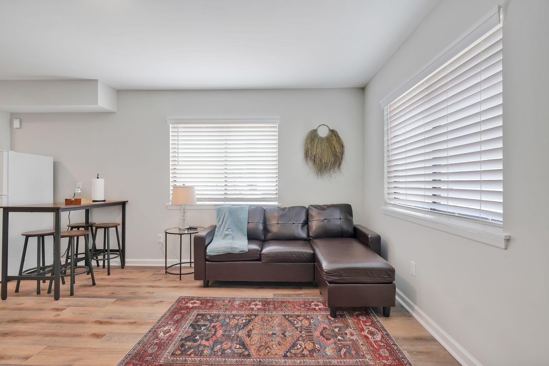 Living room with brown sectional sofa, rug, and bar seating.