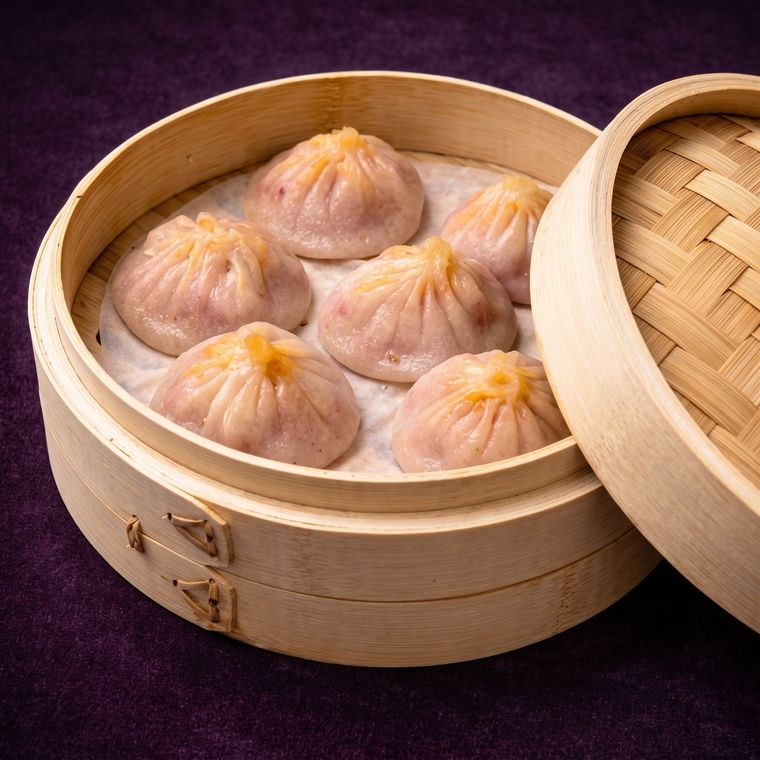 Steamed dumplings in a bamboo basket on a purple background