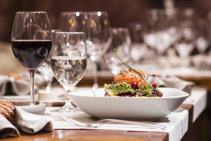 Un piatto di cibo e bicchieri di vino su un tavolo in un ristorante.