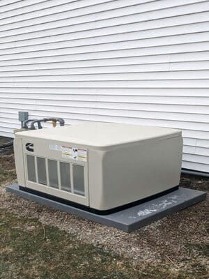 Large beige outdoor HVAC unit on a concrete pad beside white siding