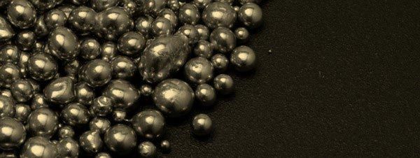 Silver spheres on a dark surface, tightly packed.