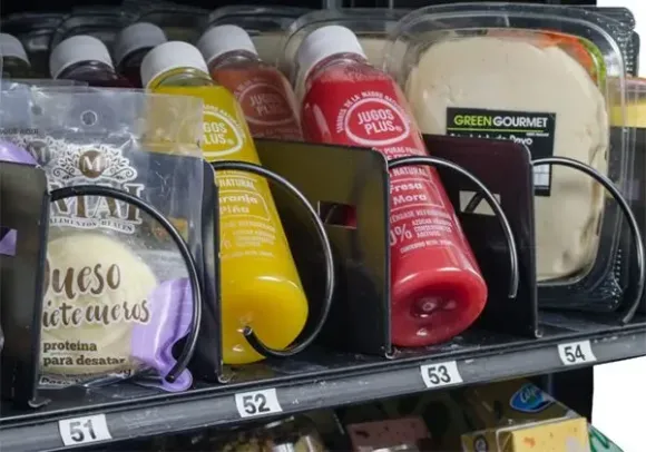 Surtido de salsas y condimentos embotellados expuestos en un estante de la tienda, con etiquetas y precios coloridos.