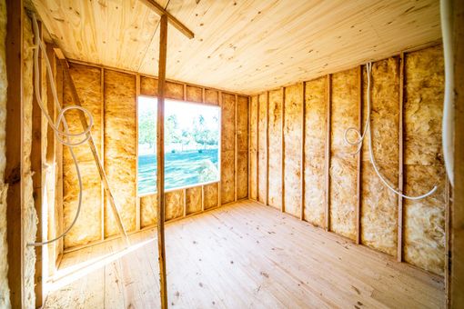 An empty room with wooden walls and a window in a house under construction. An empty room with wooden walls and a window in a house under construction.