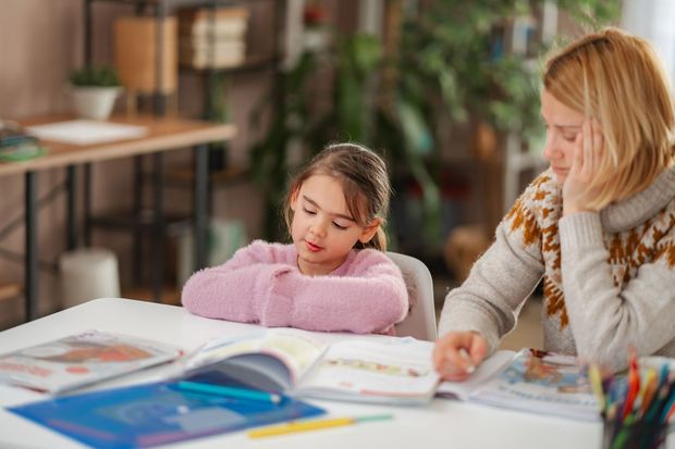 Colorful preschool classroom with small tables, chairs, rugs, toys, and wall art.