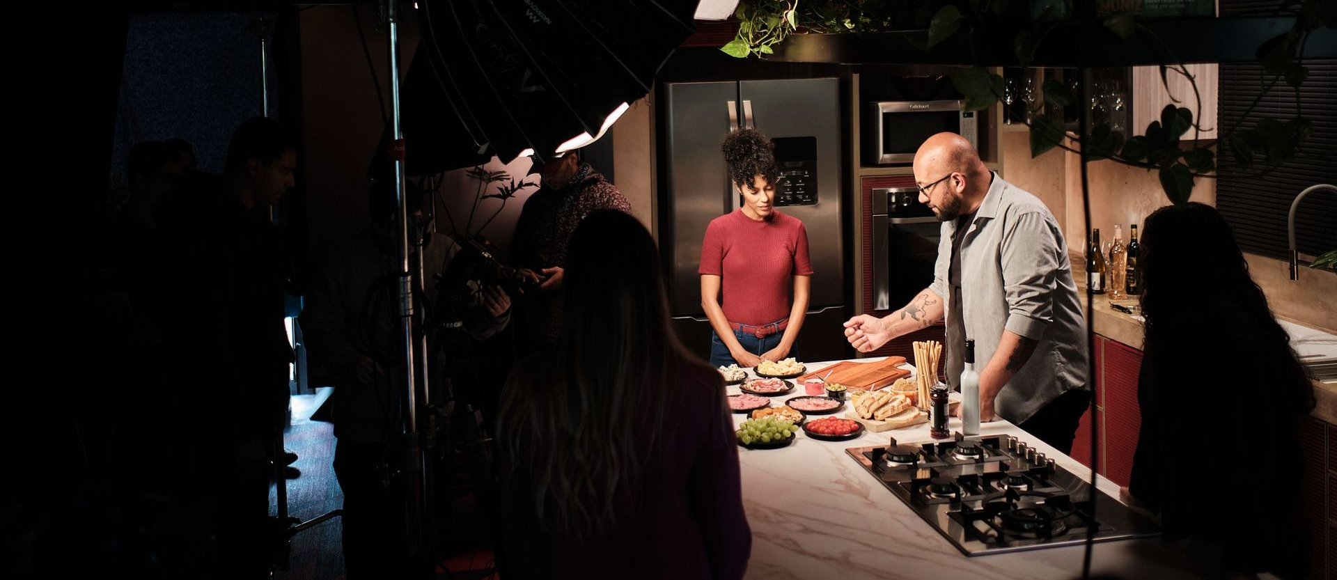 Uma equipe de filmagem prepara uma cena de comida em uma cozinha. 